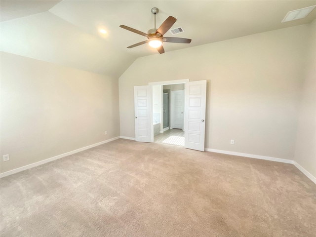 unfurnished bedroom featuring ceiling fan, light colored carpet, and vaulted ceiling