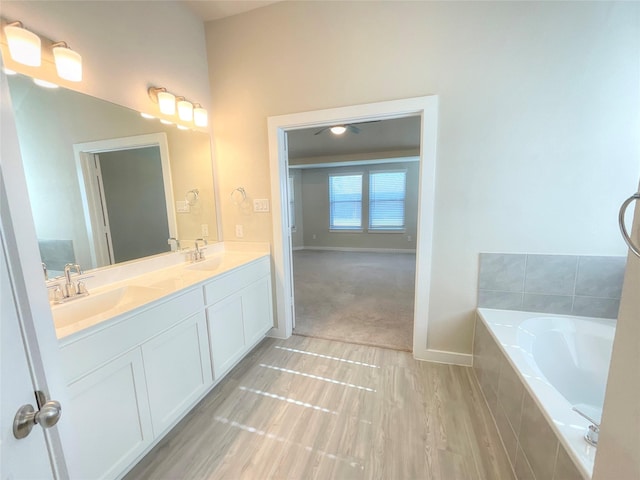 bathroom with vanity and a relaxing tiled tub