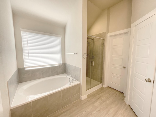 bathroom featuring plus walk in shower, hardwood / wood-style floors, and vaulted ceiling