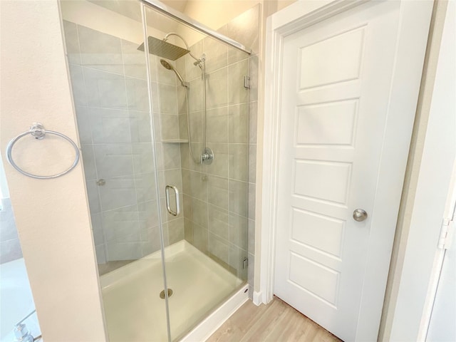 bathroom with wood-type flooring and an enclosed shower