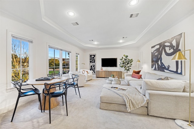 carpeted living room featuring ornamental molding and a tray ceiling