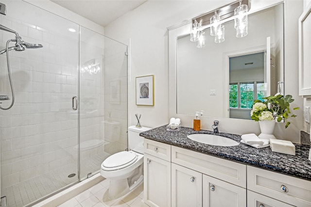 bathroom featuring tile patterned flooring, vanity, toilet, and walk in shower