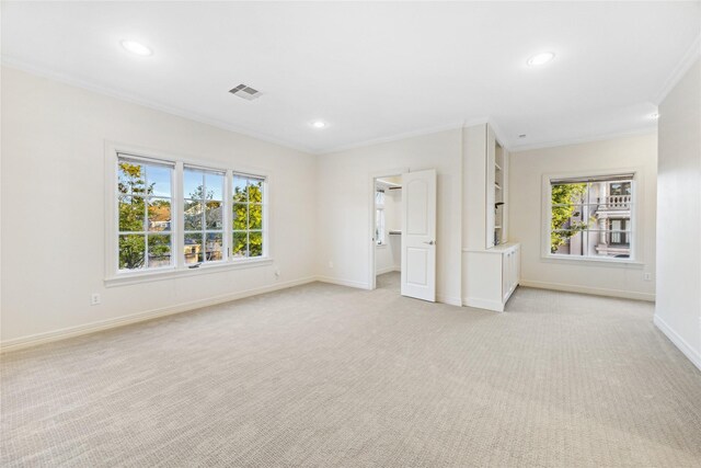 interior space featuring plenty of natural light, ornamental molding, and light carpet