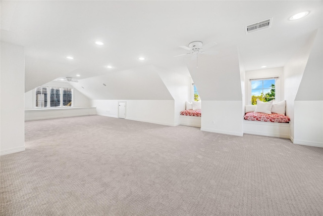 additional living space featuring ceiling fan, light colored carpet, and lofted ceiling