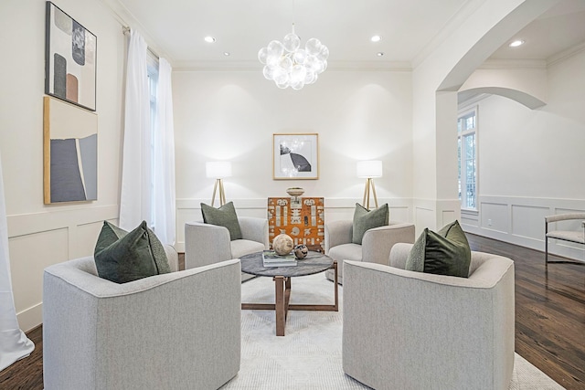 living room featuring hardwood / wood-style flooring, ornamental molding, and a chandelier