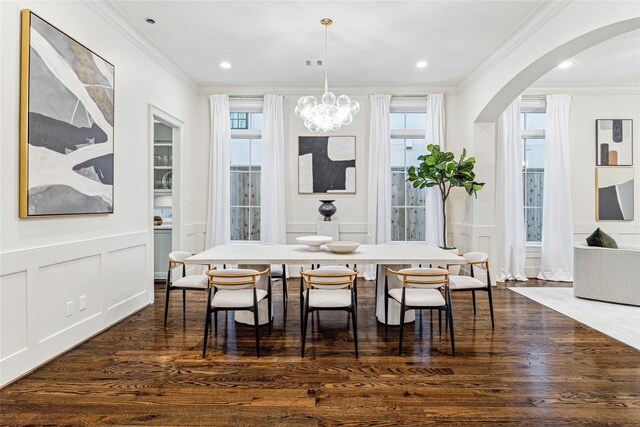 dining room with crown molding, dark hardwood / wood-style floors, and an inviting chandelier