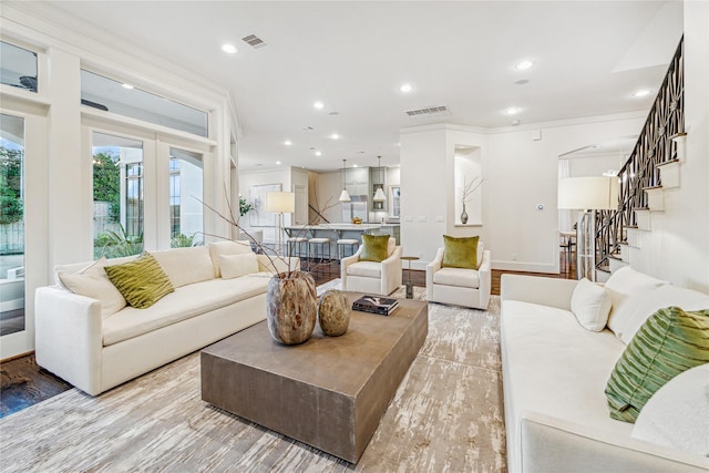 living room with crown molding and light wood-type flooring