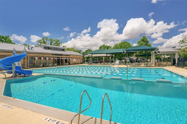 view of swimming pool with a patio and a water slide