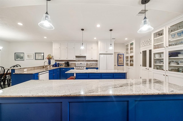 kitchen featuring white appliances, blue cabinets, hanging light fixtures, and a spacious island