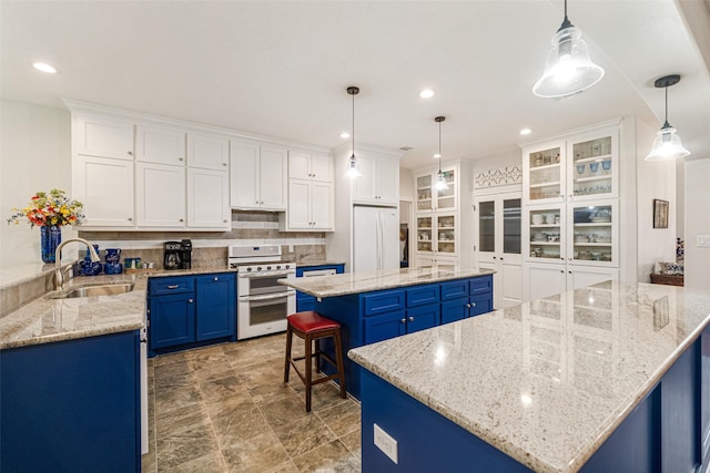 kitchen featuring white cabinetry, sink, blue cabinets, a spacious island, and white appliances