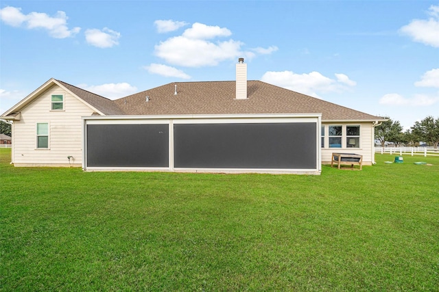 rear view of house featuring a yard