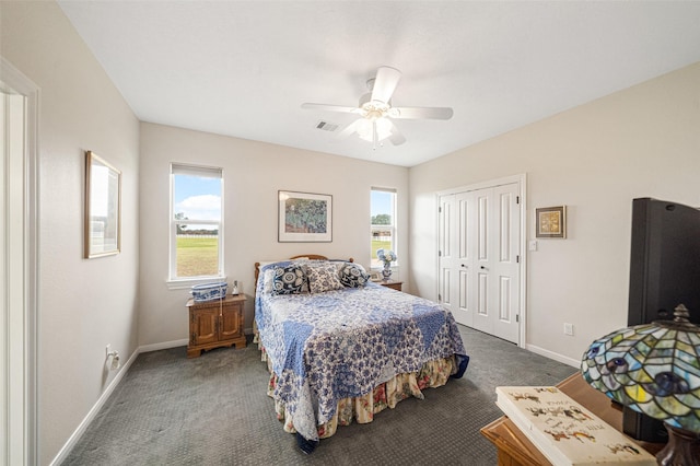 bedroom with ceiling fan, a closet, and dark colored carpet