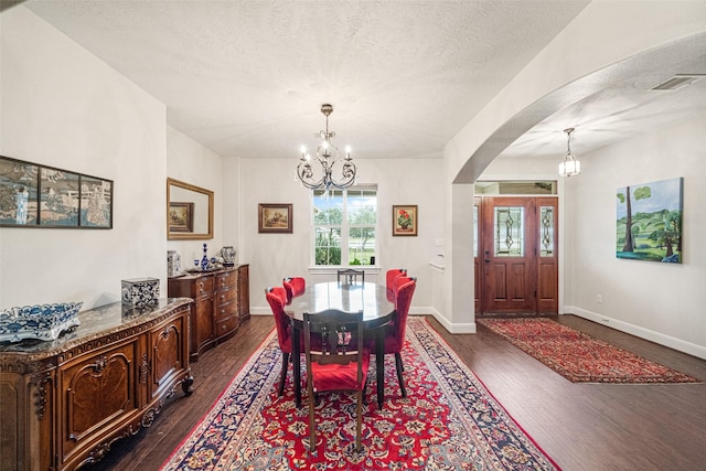 dining space featuring a chandelier, a textured ceiling, and dark hardwood / wood-style floors