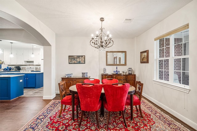 dining space featuring a notable chandelier and dark hardwood / wood-style flooring