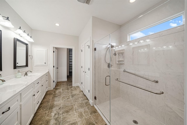 bathroom with vanity and a shower with door