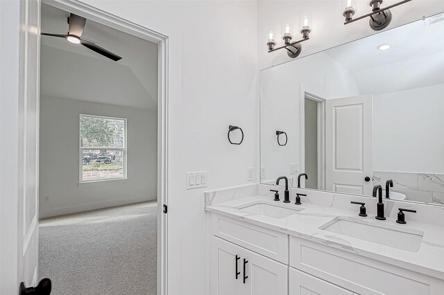 bathroom featuring ceiling fan, lofted ceiling, and vanity