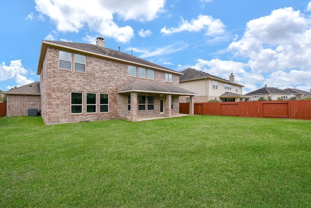 back of property with a lawn, central air condition unit, and a patio