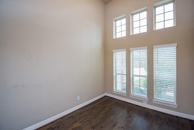 unfurnished room featuring dark hardwood / wood-style floors and a healthy amount of sunlight