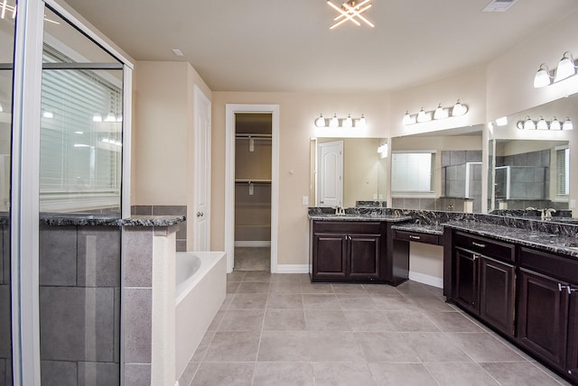 bathroom with tile patterned floors, vanity, and shower with separate bathtub