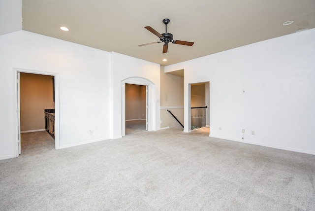 carpeted spare room with ceiling fan and vaulted ceiling