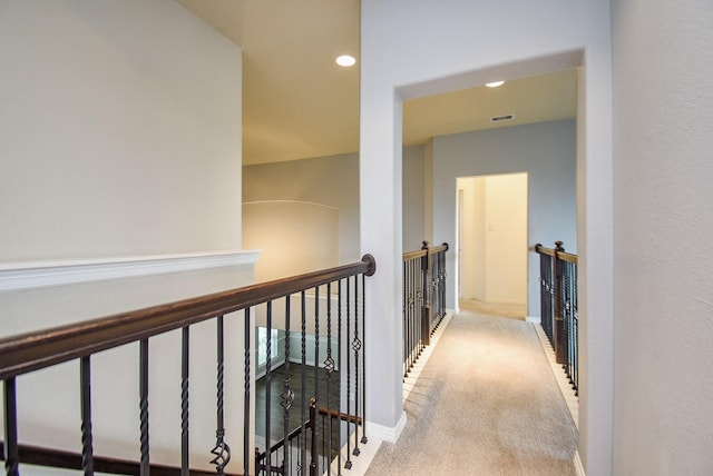 hallway featuring light colored carpet