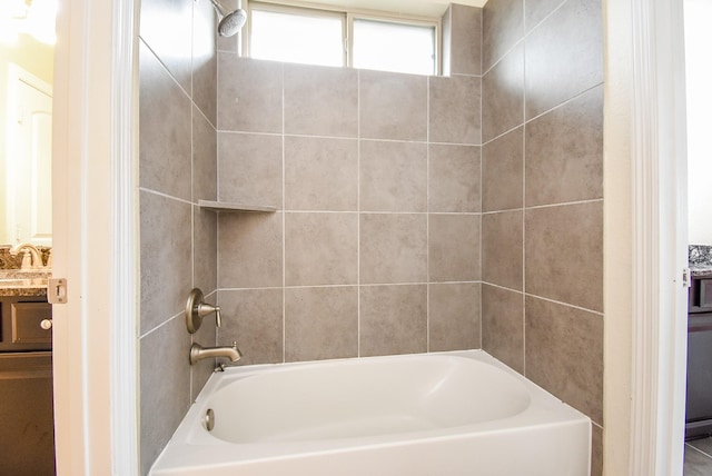 bathroom featuring vanity and tiled shower / bath