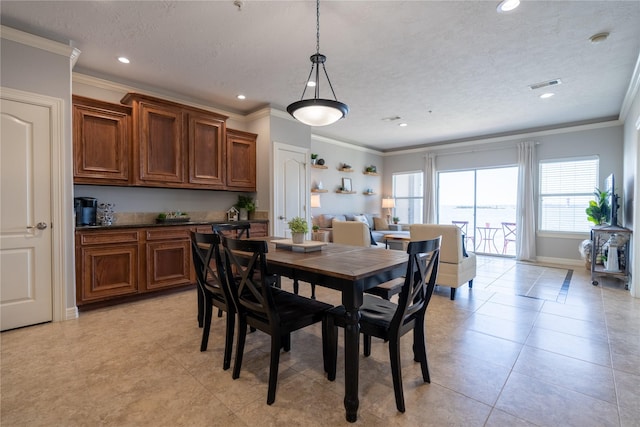 tiled dining space featuring a textured ceiling and ornamental molding