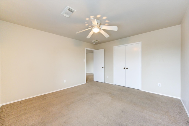 unfurnished bedroom with a closet, ceiling fan, and light colored carpet