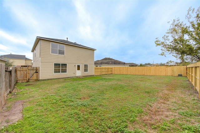 rear view of property featuring a lawn