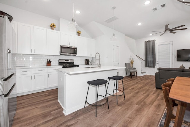 kitchen with pendant lighting, dark hardwood / wood-style floors, white cabinets, and stainless steel appliances