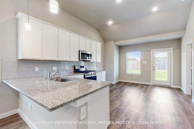 kitchen featuring sink, dark wood-type flooring, stainless steel appliances, lofted ceiling, and white cabinets