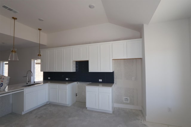 kitchen with a sink, visible vents, unfinished concrete floors, and vaulted ceiling