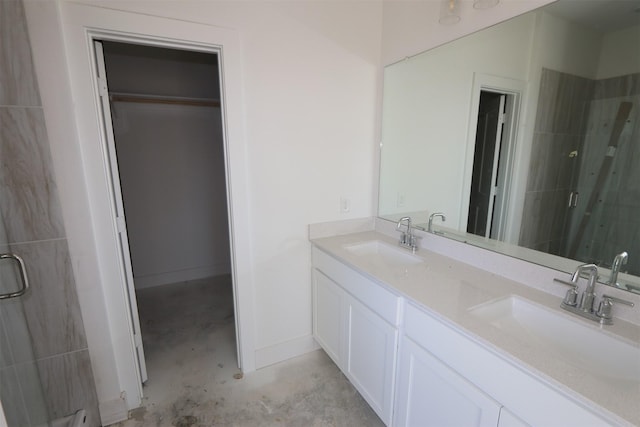 bathroom with a sink, concrete floors, a shower stall, and double vanity