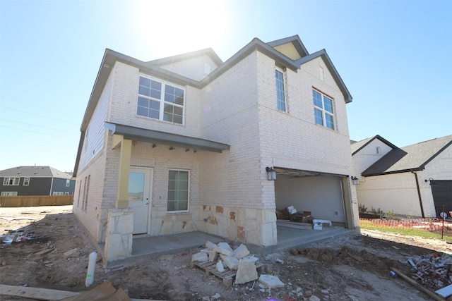 rear view of property featuring brick siding and an attached garage