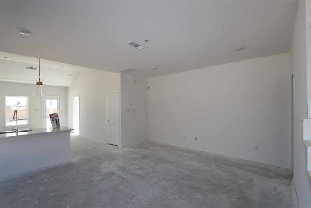 unfurnished living room with visible vents, concrete floors, and a sink