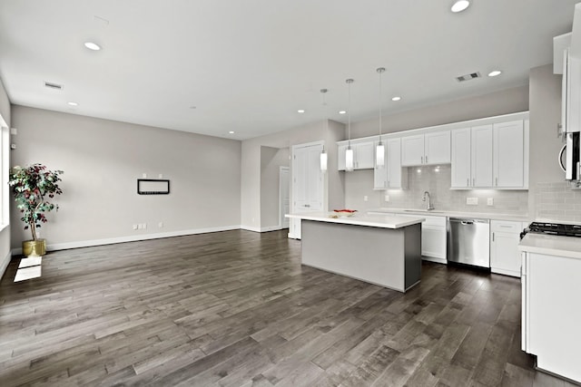 kitchen featuring a center island, sink, hanging light fixtures, appliances with stainless steel finishes, and white cabinetry