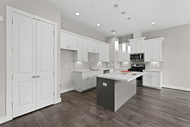 kitchen featuring white cabinets, a center island, stainless steel appliances, and hanging light fixtures