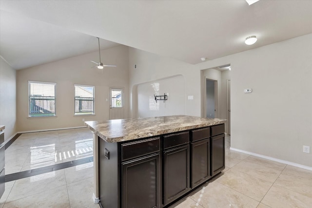 kitchen featuring ceiling fan, a kitchen island, light tile patterned floors, and high vaulted ceiling