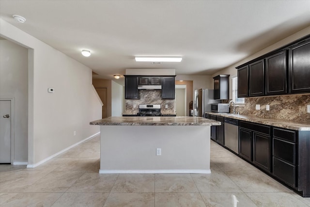 kitchen featuring sink, tasteful backsplash, light tile patterned flooring, a kitchen island, and appliances with stainless steel finishes