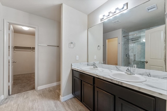 bathroom featuring hardwood / wood-style floors, vanity, and walk in shower