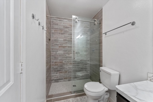 bathroom with vanity, toilet, and a shower with shower door