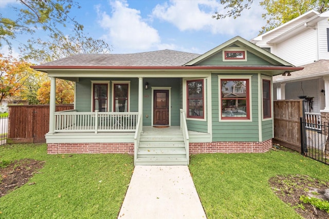 bungalow with a porch and a front lawn