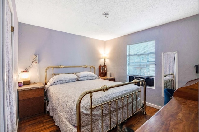 bedroom featuring a textured ceiling and dark hardwood / wood-style floors