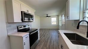 kitchen with stainless steel appliances, white cabinetry, sink, and decorative backsplash