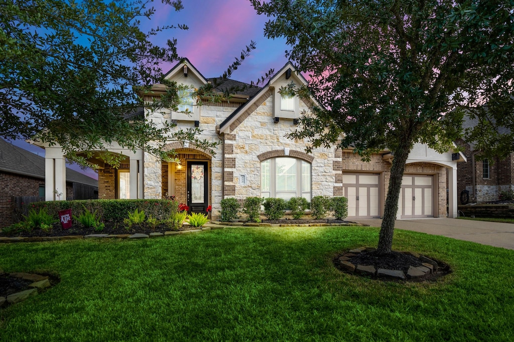 view of front of house with a garage and a yard