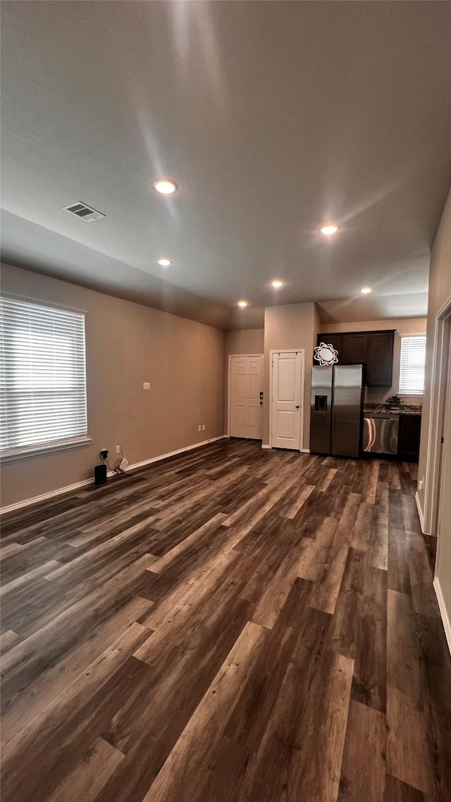 unfurnished living room featuring dark hardwood / wood-style flooring and plenty of natural light