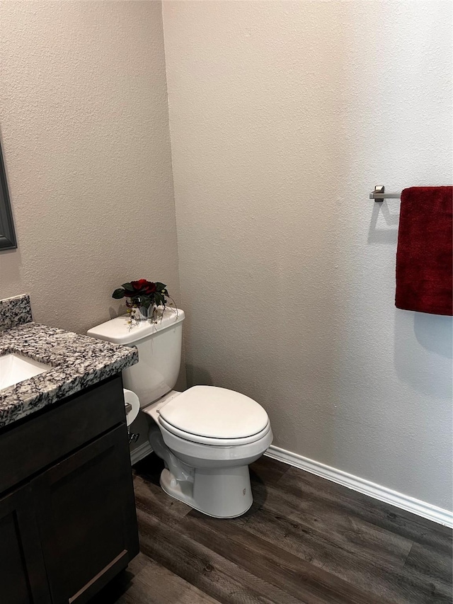 bathroom featuring toilet, vanity, and hardwood / wood-style flooring