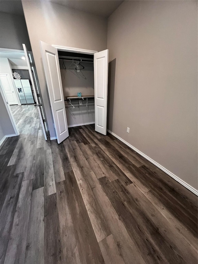 unfurnished bedroom featuring dark hardwood / wood-style floors and a closet