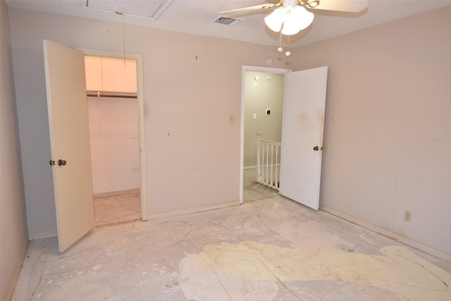 unfurnished bedroom featuring ceiling fan, a spacious closet, and a closet