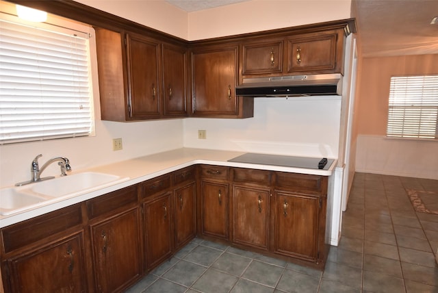 kitchen featuring black electric stovetop, tile patterned floors, and sink